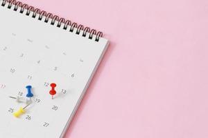 primer plano del calendario sobre el fondo rosa de la mesa. espacio de copia vacío para texto. foto