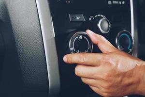 Closeup of hand driver man checking switch adjusting air from conditioning the cooling system with flow of cold in car. Leave space for writing text. photo