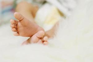 cerrar los pies del bebé recién nacido en las manos de la madre. los pies del bebé en manos con forma de mujer mamá y su hijo. hermosa imagen conceptual de la maternidad foto