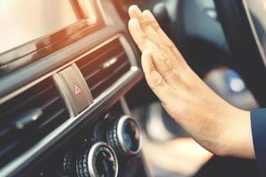 primer plano de un conductor de mano comprobando el aire de ajuste del acondicionamiento del sistema de refrigeración con flujo de aire frío en el coche. dejar espacio para escribir texto. foto