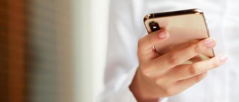 close up hand young woman in watching message on mobile smart phone during break. using cell phones to communicate in the online world. with blank or empty black screen photo