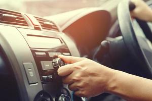 close up hand open car radio listening. Car Driver changing turning button Radio Stations on His Vehicle Multimedia System. Modern touch screen Audio stereo System. transportation and vehicle concept photo