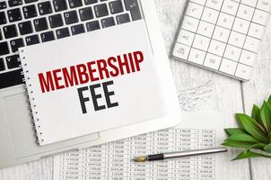 MEMBERSHIP FEE text and notepad with pen, charts and calculator photo