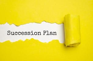 SUCCESSION PLAN text on torn paper , yellow background photo