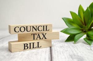 COUNCIL TAX BILL text on wooden block and plant photo