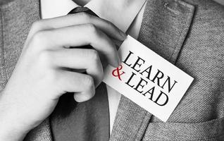 learn and lead words on card in man hand photo