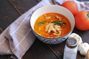Chicken panang curry in a Thai style dish served on a black wooden table. photo
