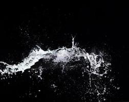 Water splash in air drop over black background, studio lighting high speed photo