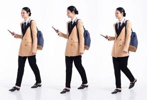 Full length 20s young Mix Race Woman business salesman backpacks, walking forward left right, wear formal blazer and shoes. Office female stands feels happy smile over white background isolated photo