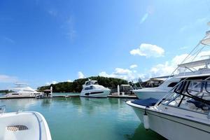 Many Luxury Yachts float on crystal clear sea in Marina Bay Club, expensive Private boat stay calm in docking pier under summer blue sky green ocean photo