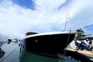 muchos yates de lujo flotan en un mar cristalino en el club de marina bay, un costoso barco privado mantiene la calma en el muelle de atraque bajo el cielo azul del verano océano verde foto