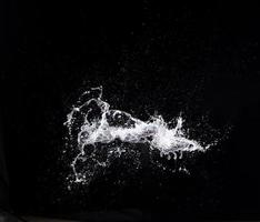 Water splash in air drop over black background, studio lighting high speed photo