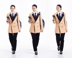 Full length 20s young Mix Race Woman business salesman backpacks, walking forward left right, wear formal blazer and shoes. Office female stands feels happy smile over white background isolated photo