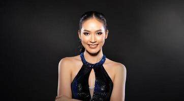 medio cuerpo de una mujer hermosa asiática usa un vestido azul de lentejuelas de noche, poses vintage de moda foto