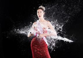 salpicaduras de agua en la parte posterior del concurso del concurso de belleza miss con banda de corona de diamantes en gota foto