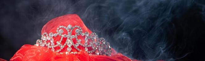 corona de plata de diamante para el concurso de reina de belleza miss pageant, joyería de tiara de cristal decorada con gemas de piedra y chispas de bokeh abstracto fondo oscuro copia espacio banner foto