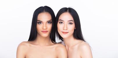 Two 2 Beautiful fresh skin women open shoulder with clean look make up and long black hair. Portrait young girls in attractive natural fashion face express feel smile, isolated white background photo