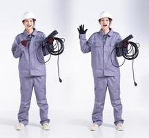 Full length 20s young Mix Race engineer electrician Woman, wow surprise glad sign, wear gray uniform. Contractor female hold electric plug cable smile happy over white background isolated photo