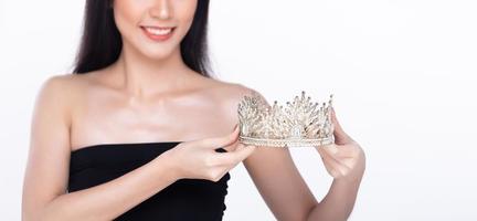 Beautiful fresh skin women hold Diamond Miss Beauty Pageant Contest Crown and long black hair. Portrait young girls in attractive natural fashion face express feel smile, isolated white background photo