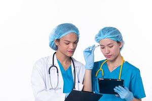 médico profesional de larga duración en uniforme de hospital discutir la condición del cuadro del paciente en la tableta. mujer practicante llevar abrigo confiado en la clínica, fondo blanco aislado foto