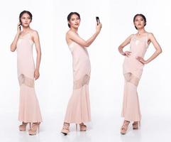 cuerpo completo de mujer hermosa asiática con vestido rosa de lentejuelas de noche, teléfono de Internet en funcionamiento foto