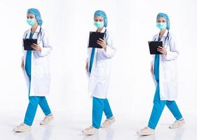 Full length 20s young Mix Race hospital Doctor Woman, walking forward left right, wear mask stethoscope coat uniform. Surgeon female feels happy smile over white background isolated photo