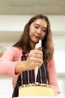 una joven adulta asiática aprende a hacer un curso en línea de pastelería en la cocina. video de la madre femenina a la clase de ciberespacio en una computadora portátil como contenido de medios sociales de blogger y aprendizaje de transmisión, espacio de copia foto