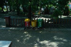 sidoarjo, marzo de 2022 - botes de basura con diferentes colores para diferentes tipos de basura en los parques de la ciudad foto