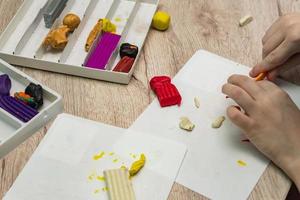 child play with plasticine. Plasticine modeling clay in children class. Development of fine motor skills of fingers. photo