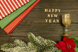 Happy New year 2021 celebration.Champagne glasses and poinsettia on wooden background. Flat lay. photo