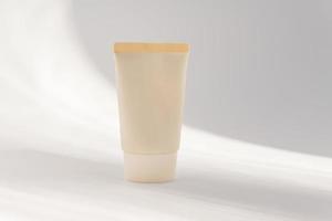 tubo de crema cosmética beige, maqueta de tarro de bálsamo sobre fondo blanco. componen el contenedor en blanco del producto. concepto de cuidado corporal y facial foto