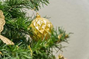 cerca de la decoración del árbol de navidad con adornos y guirnaldas. tarjeta de felicitación festiva para las vacaciones de invierno. foto