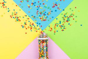 Pop colors. Festive multicolored background with bright sugar sprinkles scattered on paper. photo