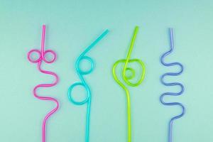 multicolored plastic cocktails straws on blue background photo