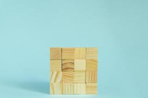 Construction of wooden cubes on blue background with copy space. Mockup composition for design photo