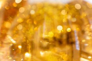 Golden glowing bokeh background. Abstract bright glittering backgdrop. Defocused image photo