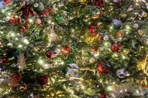 close up of christmas tree decoration with baubles and garland. Festive greeting card for winter holidays photo