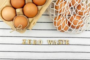 Zero waste Easter concept. No plastic bag concept. Minimal style. Beige mesh shopping bag with brown chicken eggs on textile background. photo