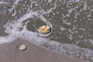 pebble coastline. Seashore with transparent water and small stones photo