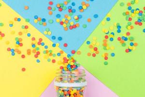 Pop colors. Festive multicolored background with bright sugar sprinkles scattered on paper. photo