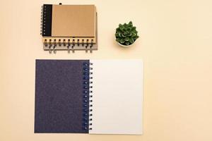 top view eco friendly stack of notebooks, with copy space, made of recycled paper on a pastel background. Mockup for your projects photo