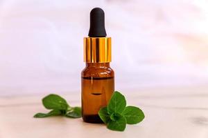 Aromatherapy concept. Aroma Scented Oil in Glass Bottle with Mint photo