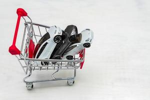 luxury toy cars Tesla models in small shopping cart on whte background. Concept of buying new luxuary car photo