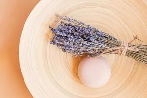 Handmade lavender Soap. bar of natural soap of ball shape with dried lavender flowers on a wooden plate. Organic cosmetics for skin care and spa photo