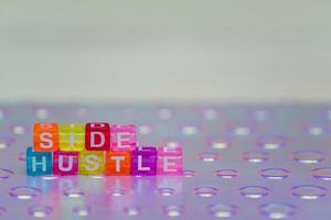 Side hustle phrase made of cube beads of different colors. Concept of additional income. photo