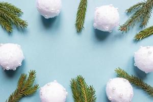Christmas minimal concept - Christmas composition with fir branches and white baubles. Horizontal frame, flat lay, view from above. Pastel blue background with copy space photo