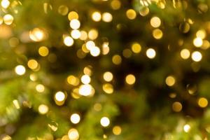 New year defocused background. Garland blurred golden lights sparkling on a christmas tree photo