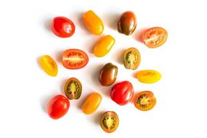 various colorful tomatoes isolated on white background. Top view, flat lay. Creative layout photo