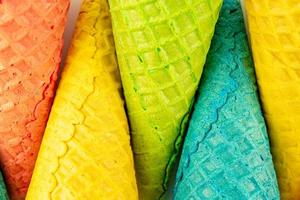 Set of various bright multicolored ice-cream waffle cones on white background . photo