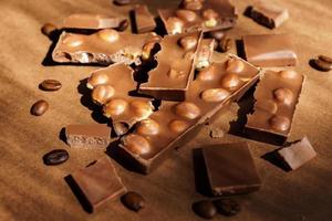 Close up of milk chocolate with hazel nuts on brown background. Sweet dessert photo